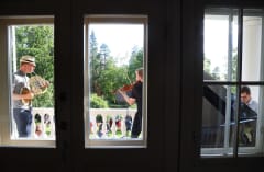 A cornist, violinist and pianist playing on a mansion terrace