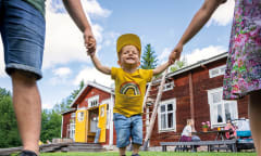 A happy little child in a yellow t-shirt.