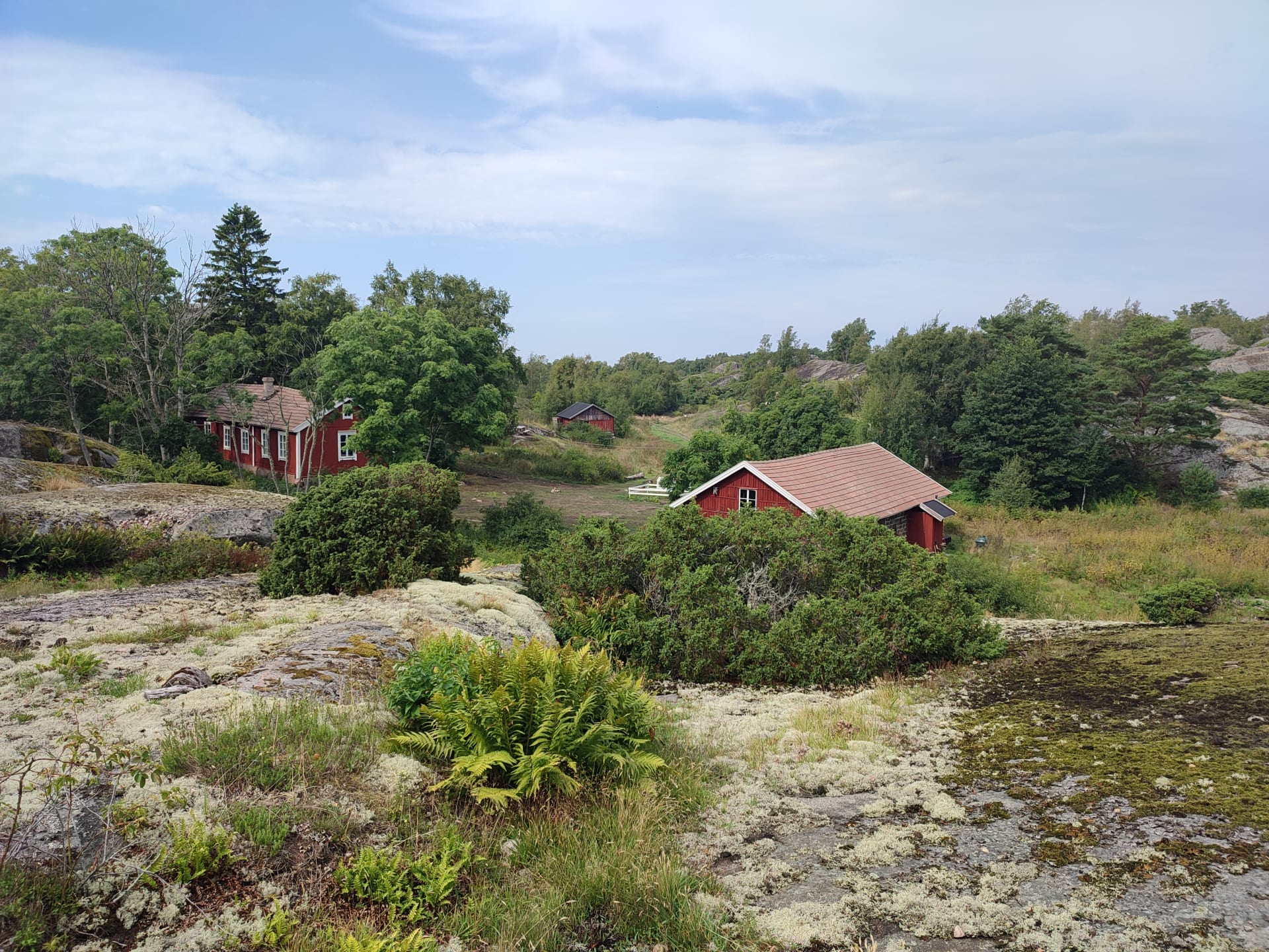 Kuva kallioltaloa. Yhdessä niistä on kesäkahvila.Picture looking down from the cliff. There are three old wooden houses in Notkelma. One of them has a summer cafe 