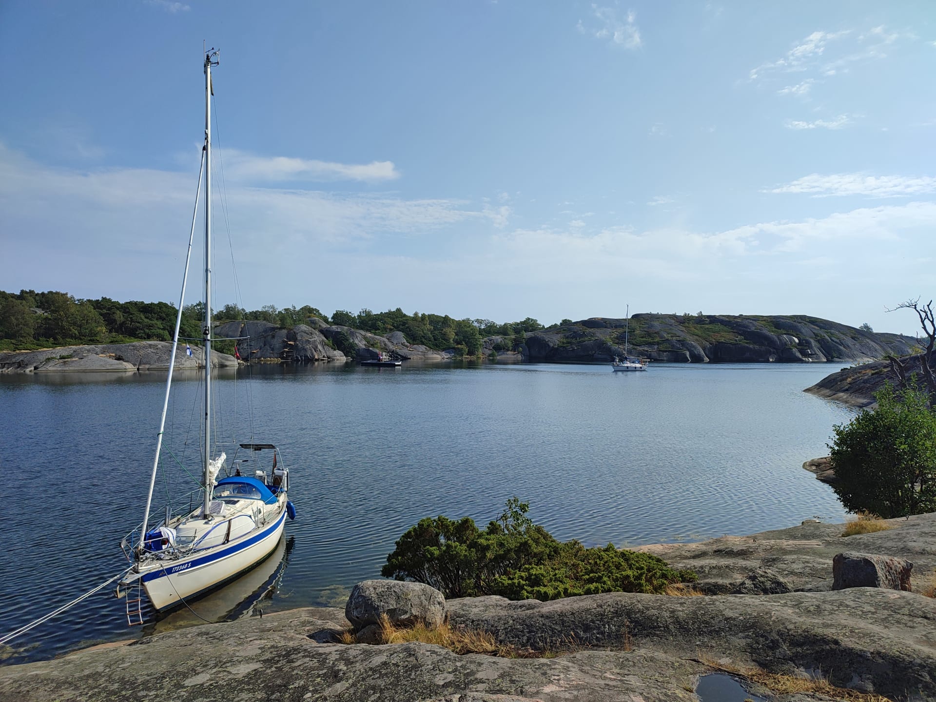 Kuva on otettu ylempää kalliolta sisälahdelle. Rantaan on kiinnittynyt iso purjevene ja toinen on saapumassa rantaan. Vastaranta on kallioinen.  Kuva on otettu ylempää kalliolta sisälahdelle. Rantaan on kiinnittynyt iso purjevene ja toinen on saapumassa rantaan. Vastaranta on kallioinen.