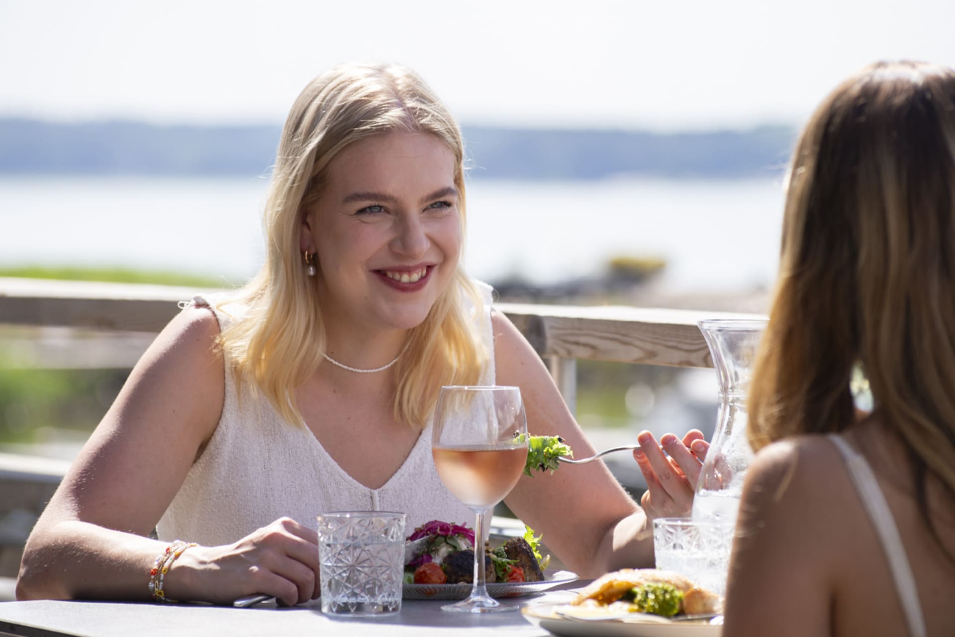 Women enjoying food on the terrace of Mathildan Marina.