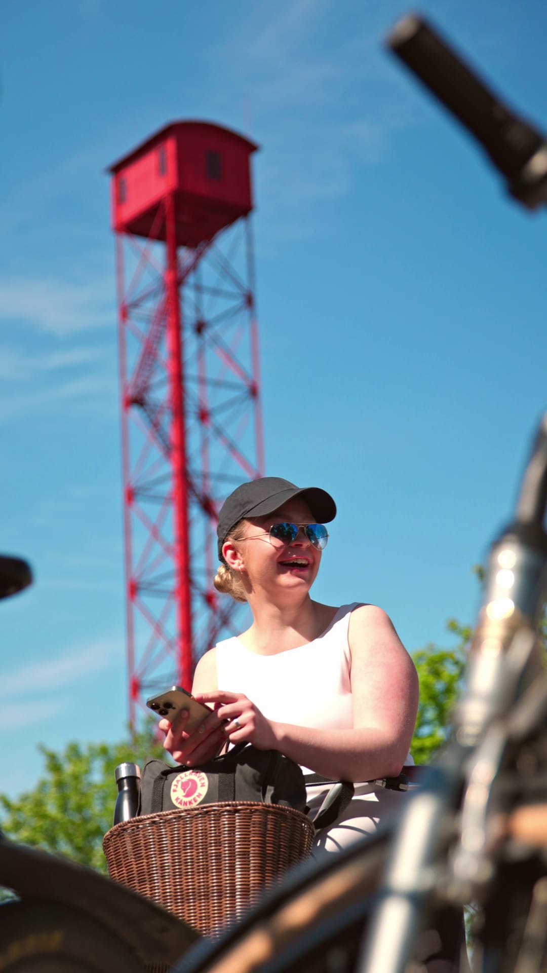 Naishenkilö kädessään kori, taustalla Pispalan haulitorni