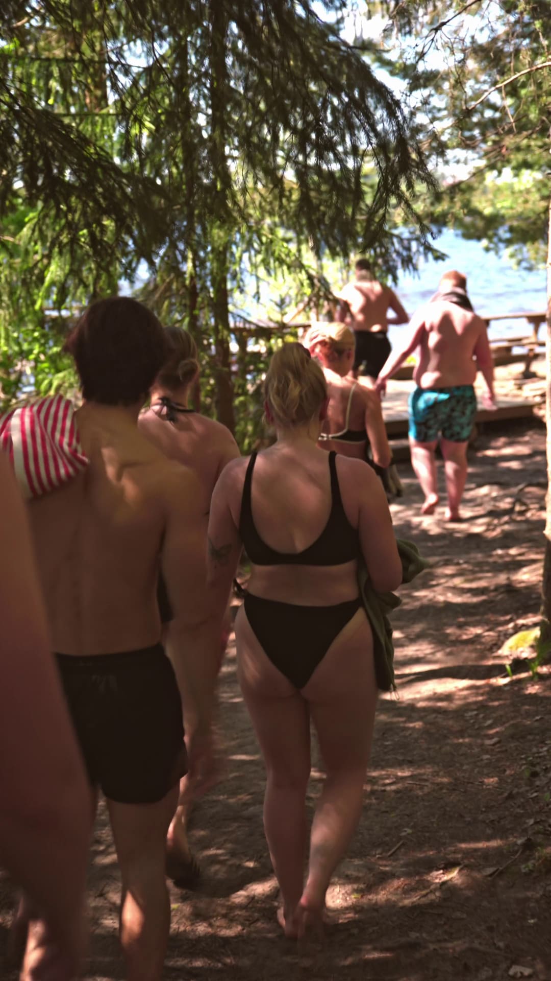 Ihmisiä kävelemässä järven rantaan