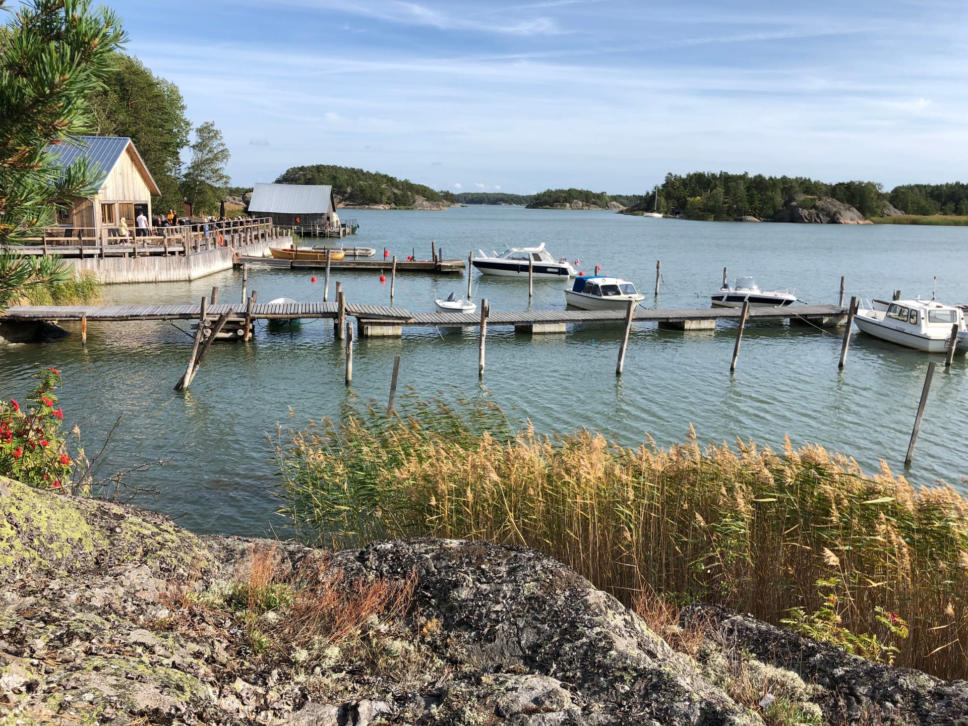 A picturesque dock with moored boats, a rustic building in the background, and lush greenery captures the essence of tranquility in the archipelago. A picturesque dock with moored boats, a rustic building in the background, and lush greenery captures the essence of tranquility in the archipelago.