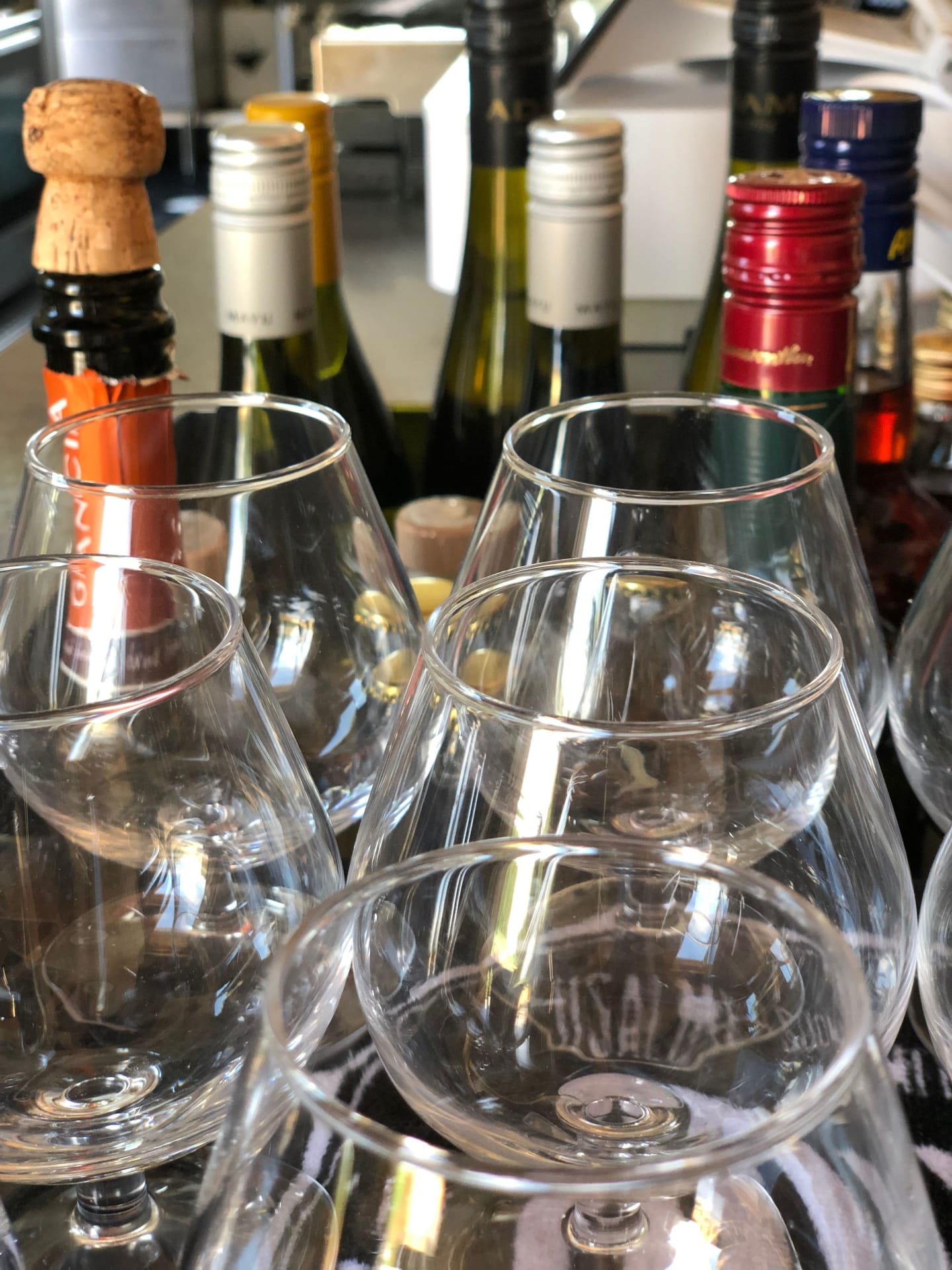 An assortment of wine glasses and bottles await guests, hinting at the promise of a convivial gathering or a fine dining experience. An assortment of wine glasses and bottles await guests, hinting at the promise of a convivial gathering or a fine dining experience.
