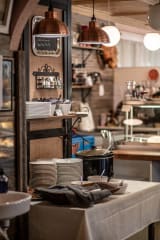 Pöytä, jonka päällä keittopata, leipää ja lautasia.