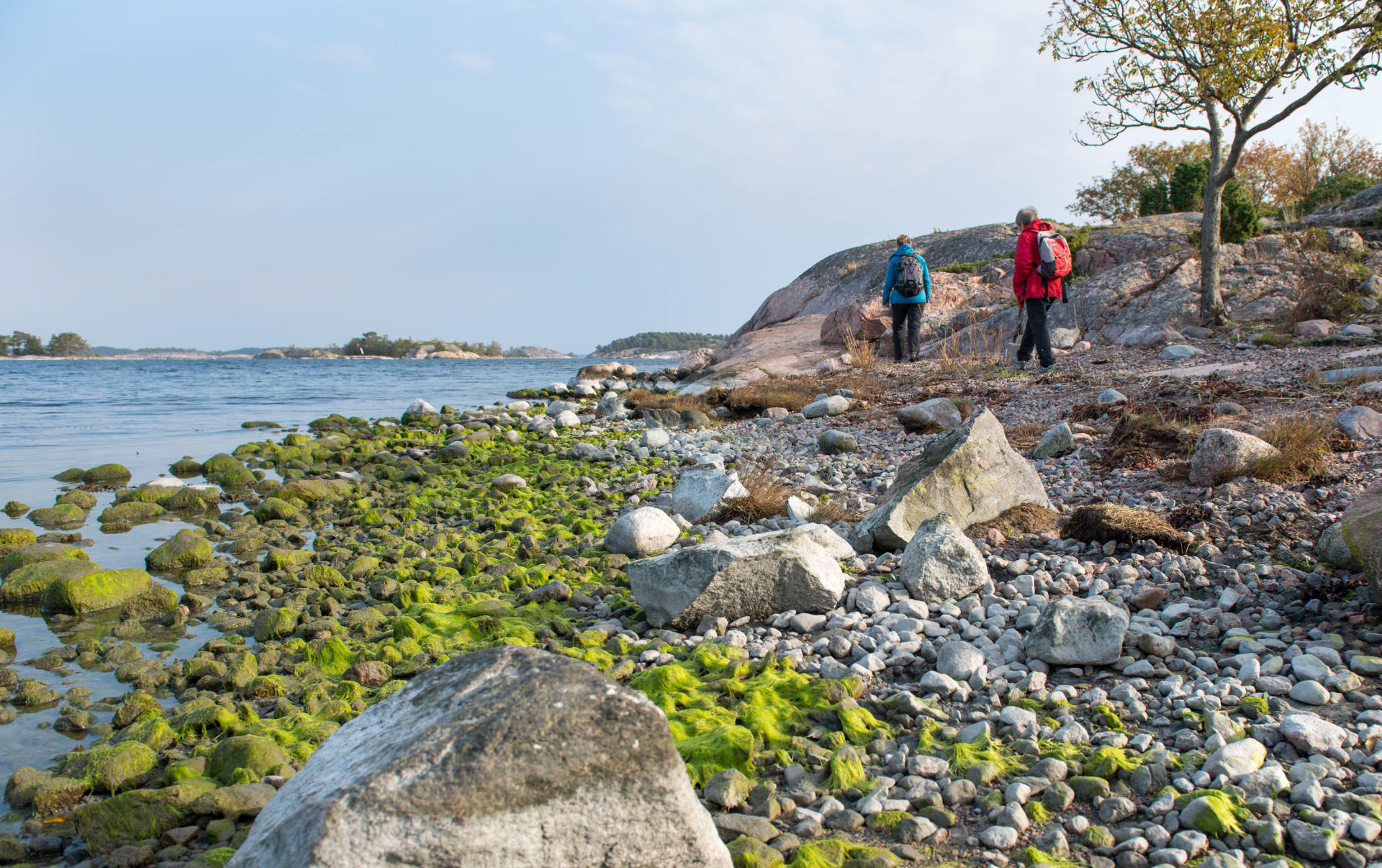 Kaksi retkeilijää kivisellä rannalla. Kaksi retkeilijää kivisellä rannalla.