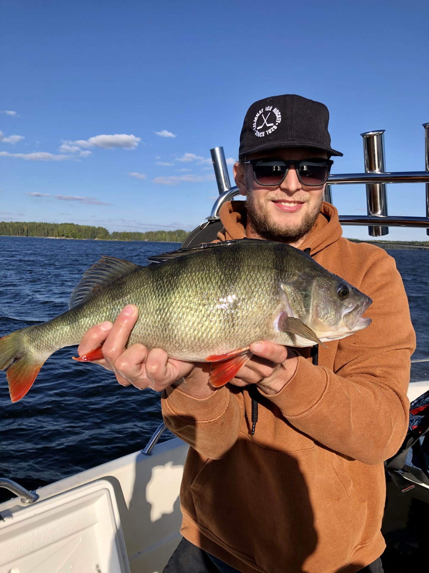 A man on a fishing trip holding a perch