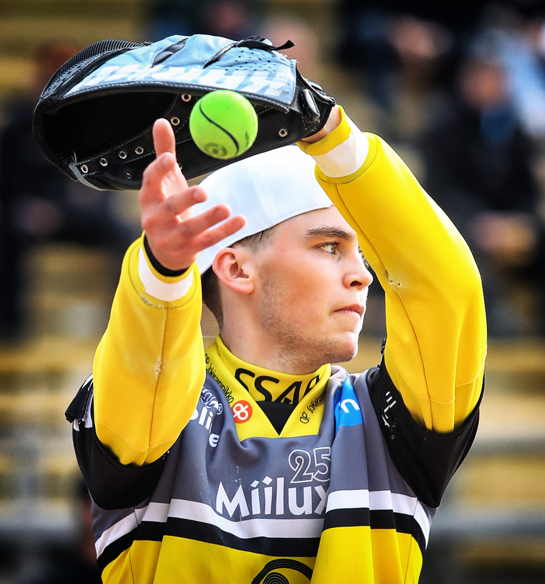 Pesäpalloilija syöttää palloa.