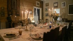 Ruokapöytä hirsiseinäisessä huoneessa.