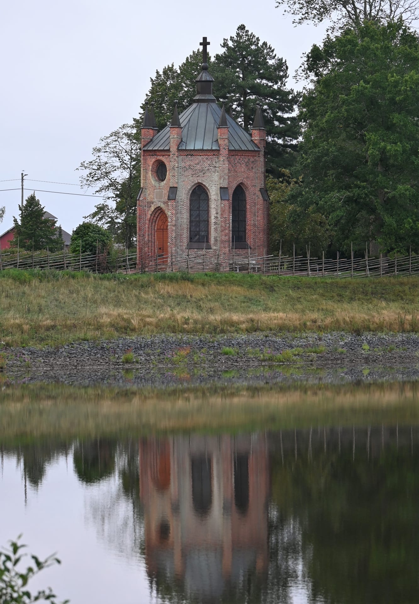 Kappeli, jonka kuva heijastuu veden pinnasta.