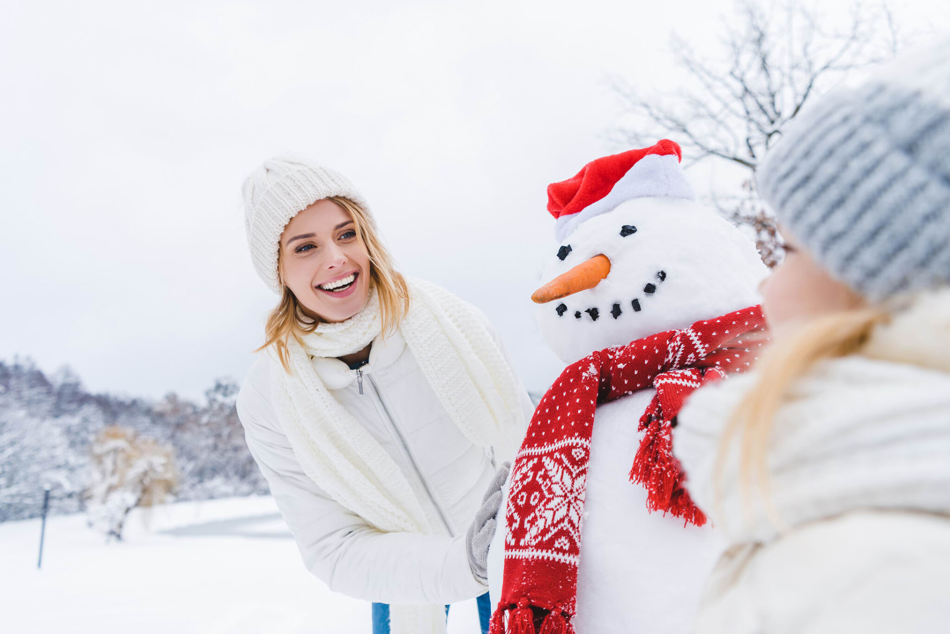 The woman smiles at the cheerful snowman. The woman smiles at the cheerful snowman.