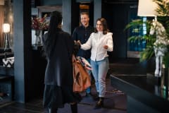 Two women and a man meeting in hotel lobby