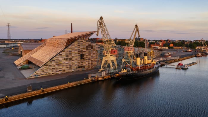 Maritime Centre Vellamo building and Icebreaker Tarmo captured from the sea in summer sunset light.