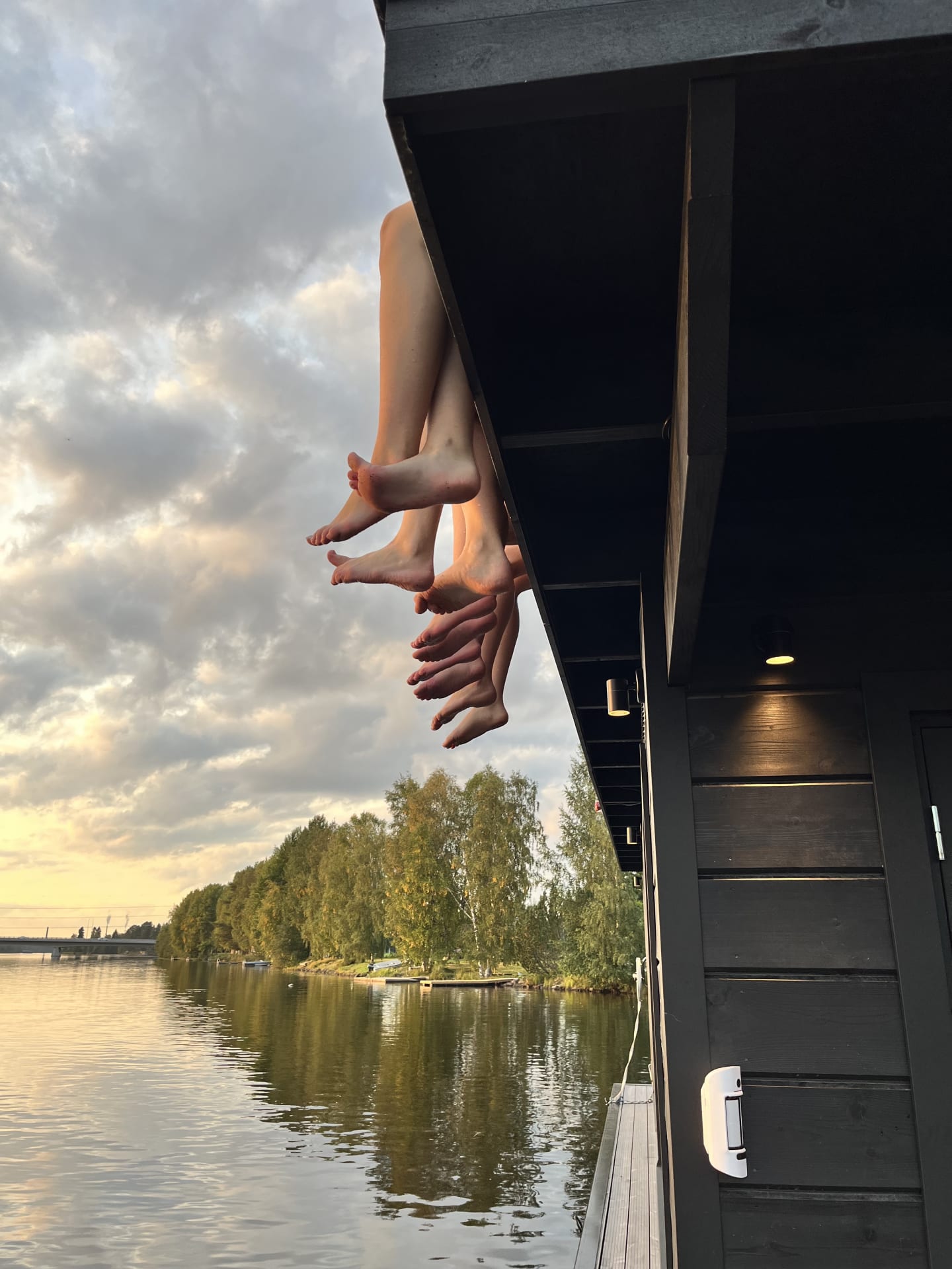 Ihmiset istumassa saunalautan katolla jokinäkymässä