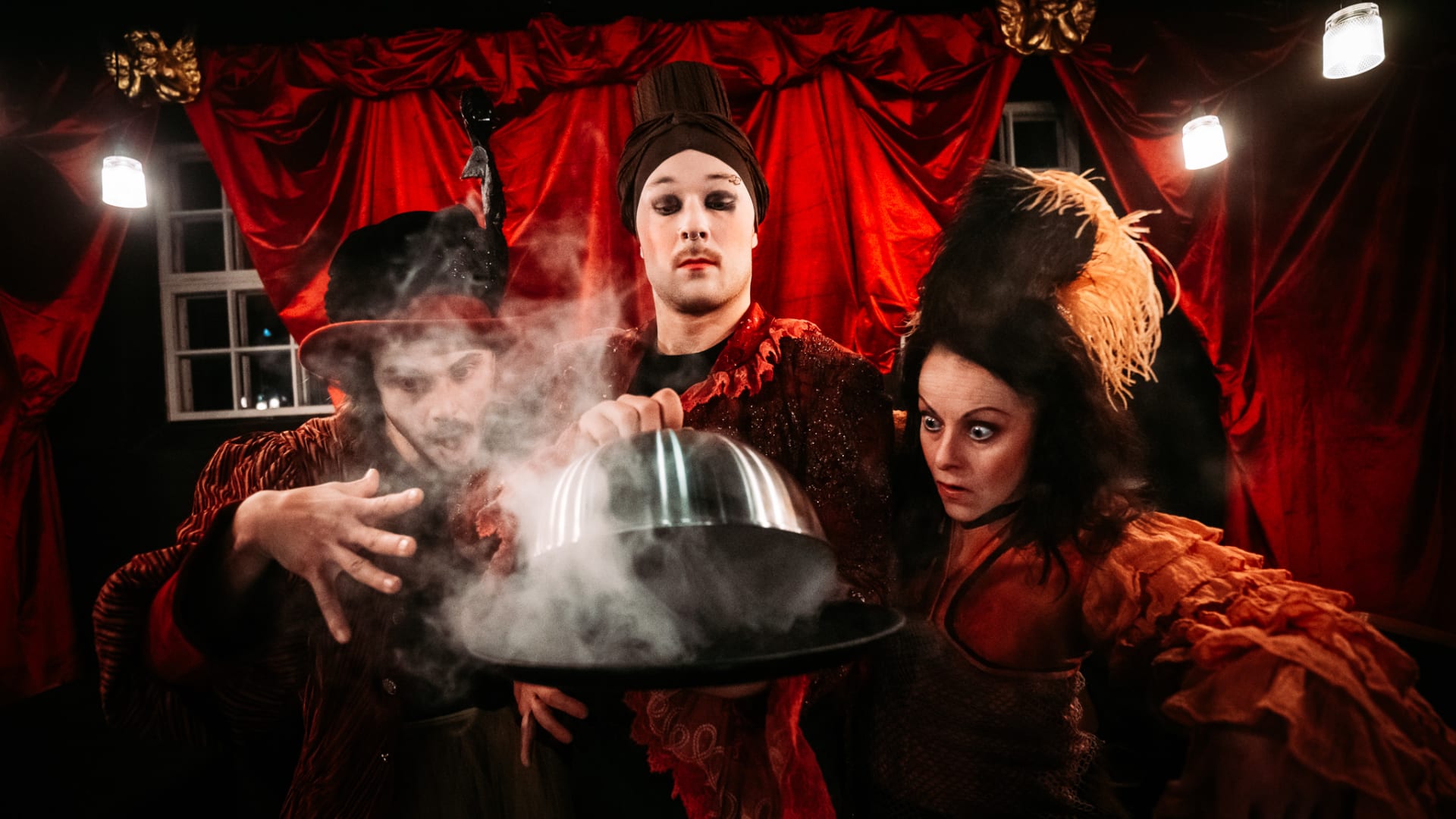 Esityksen hahmot raottavat illalliskupua, jonka reunan alta tulee höyryä Esityksen hahmot raottavat illalliskupua, jonka reunan alta tulee höyryä