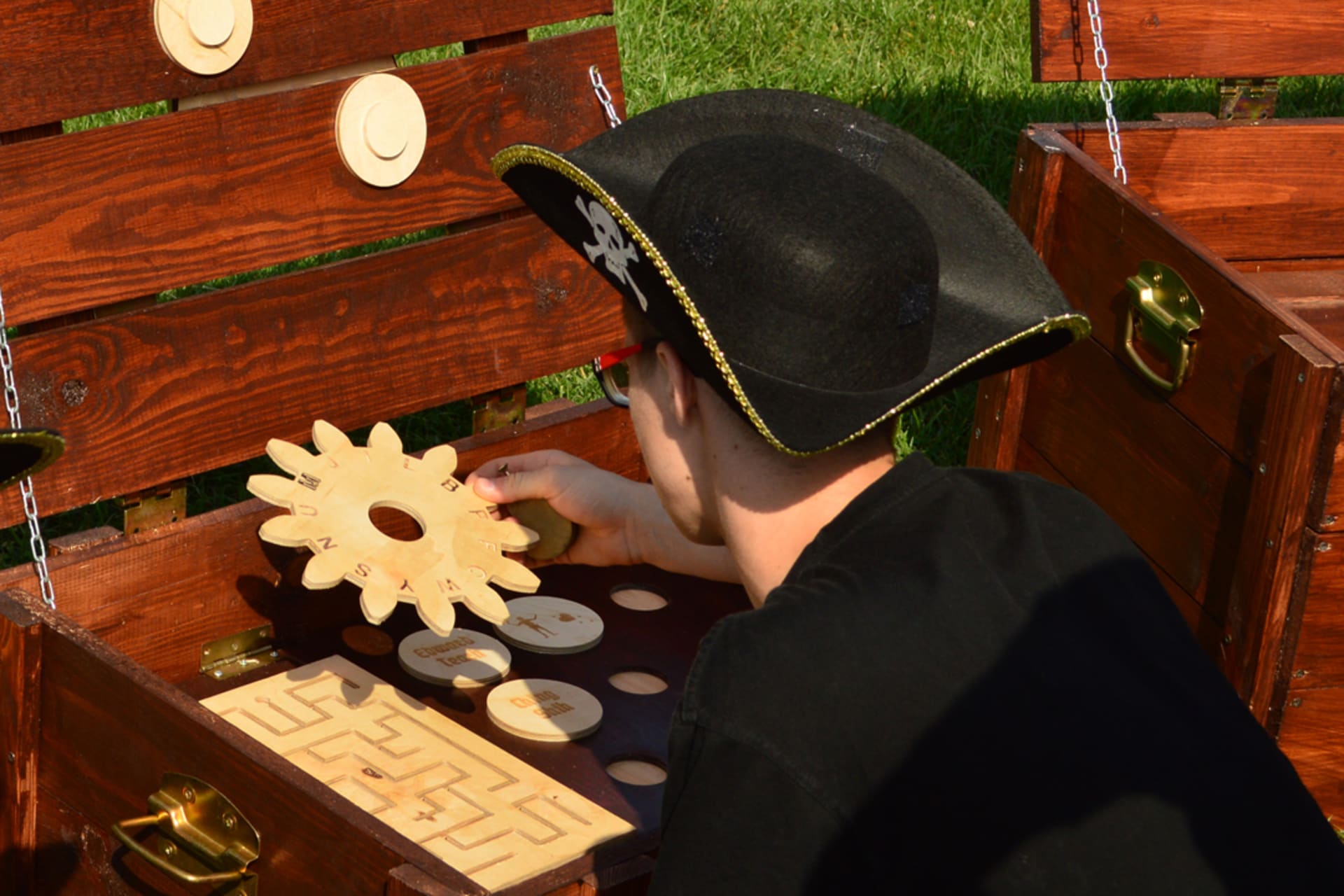 A person with the pirate hat solving a puzzle in an escape game.