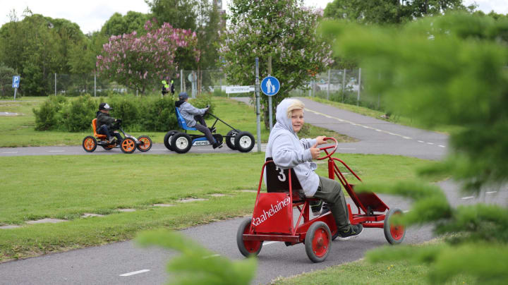 Poika ajaa punaisella polkuautolla lasten liikennepuistossa Raahessa