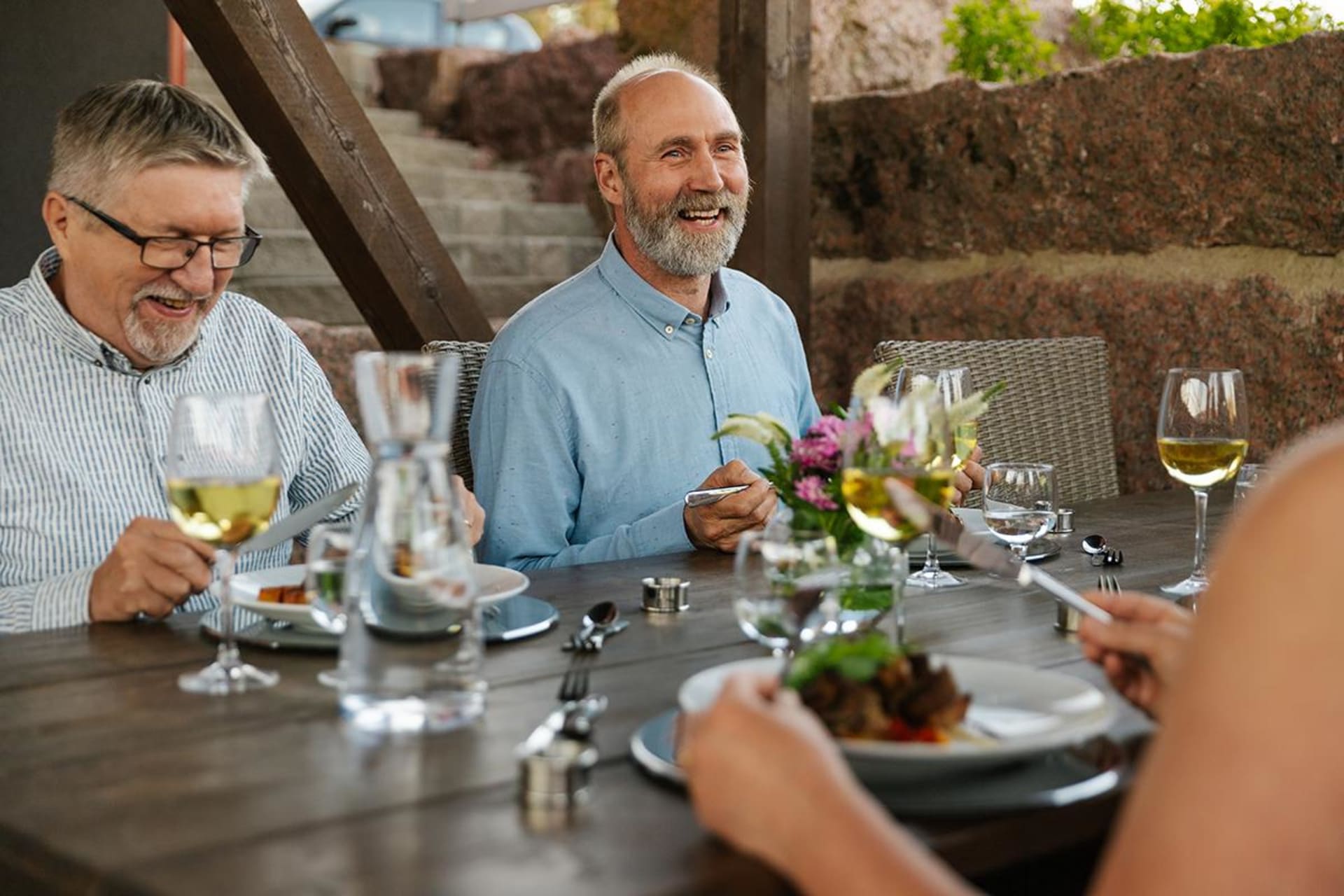 Happy people dining at Juureskellari table. 