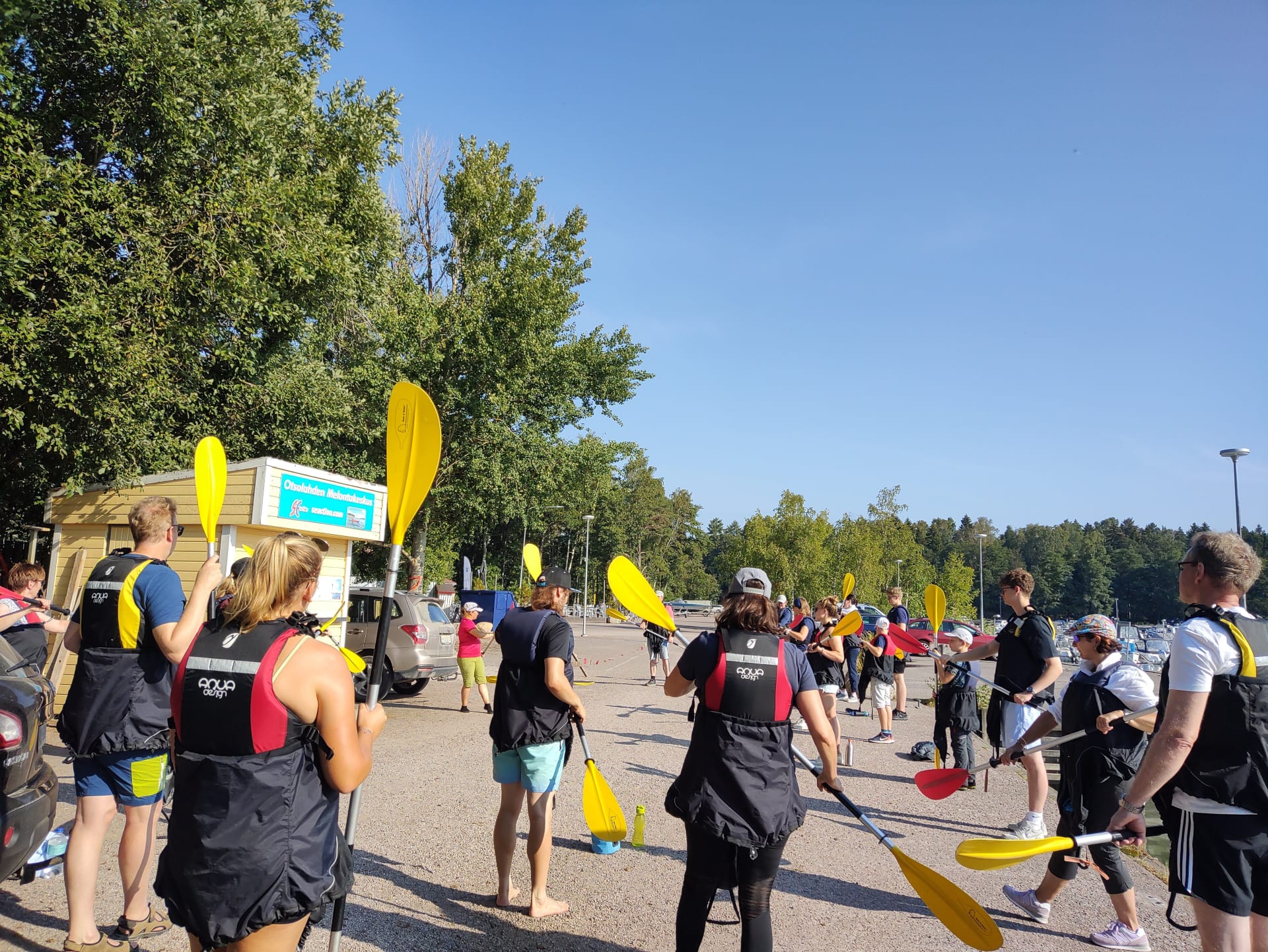 En grupp får instruktioner om paddlingstekniker på land