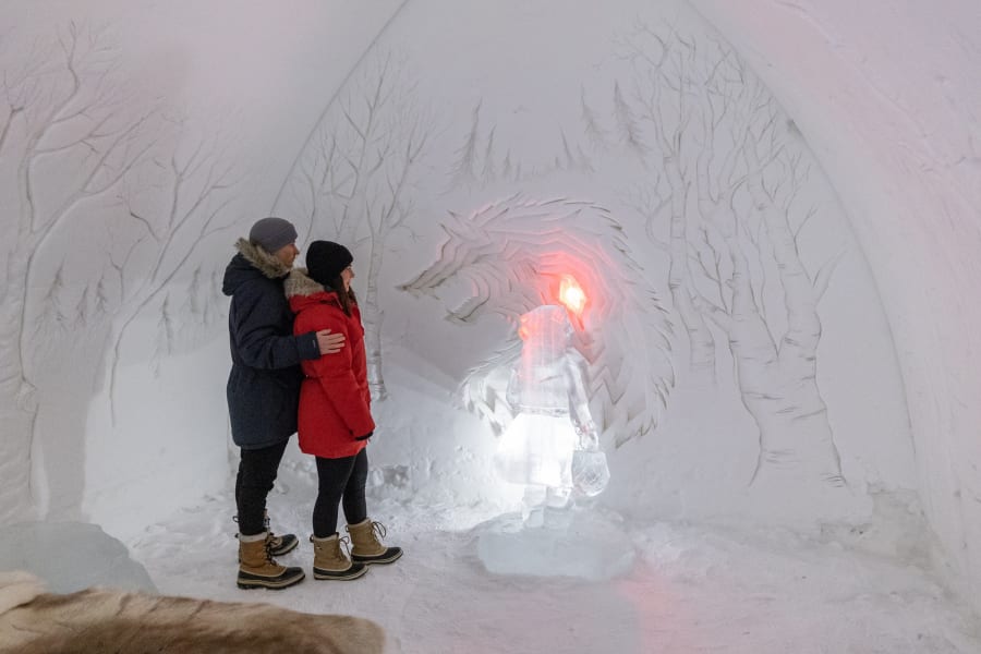 Couple looking at ice art inside Arctic SnowHotel.