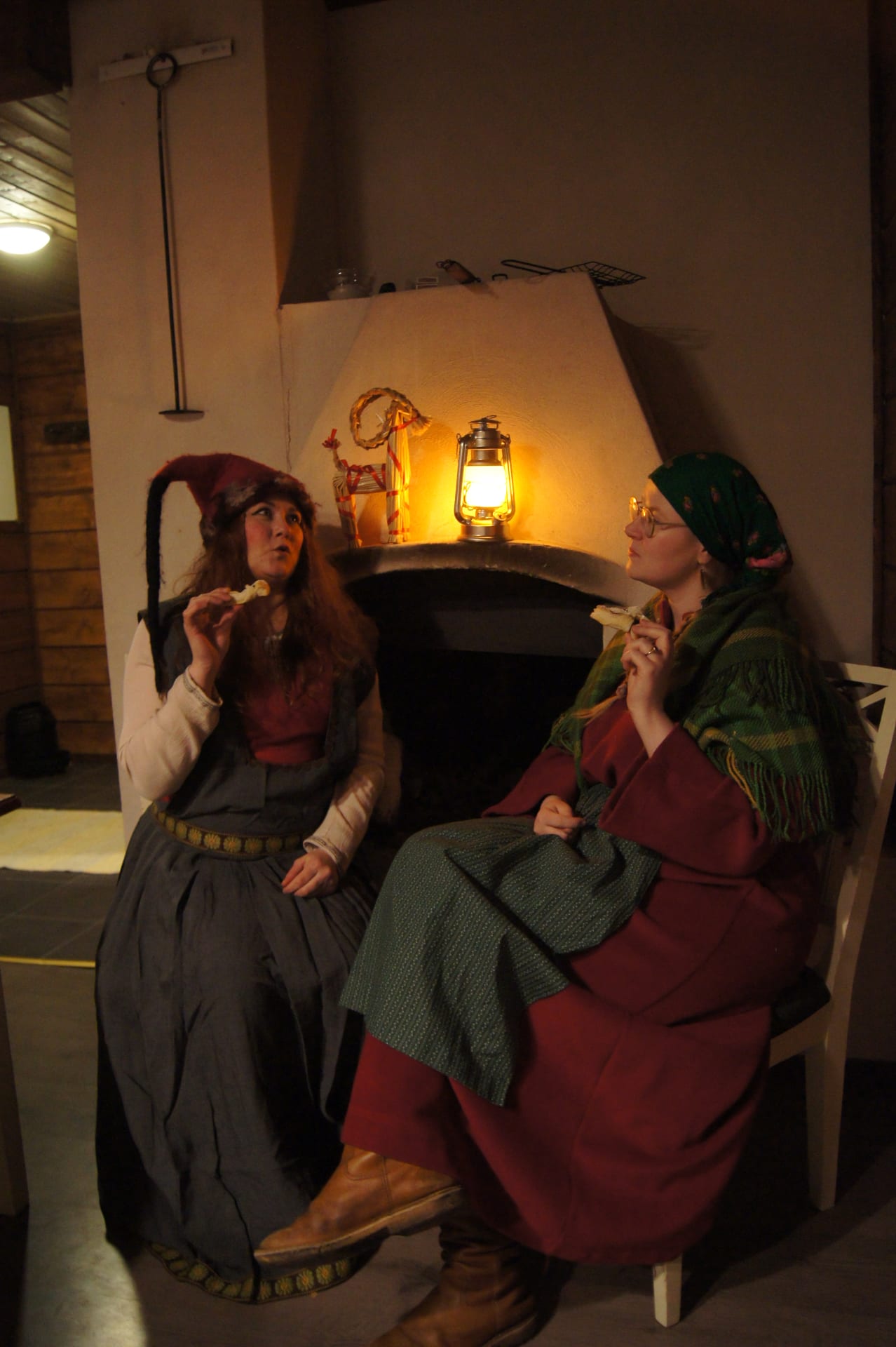 Two women enjoying Christmas treats by a fireplace