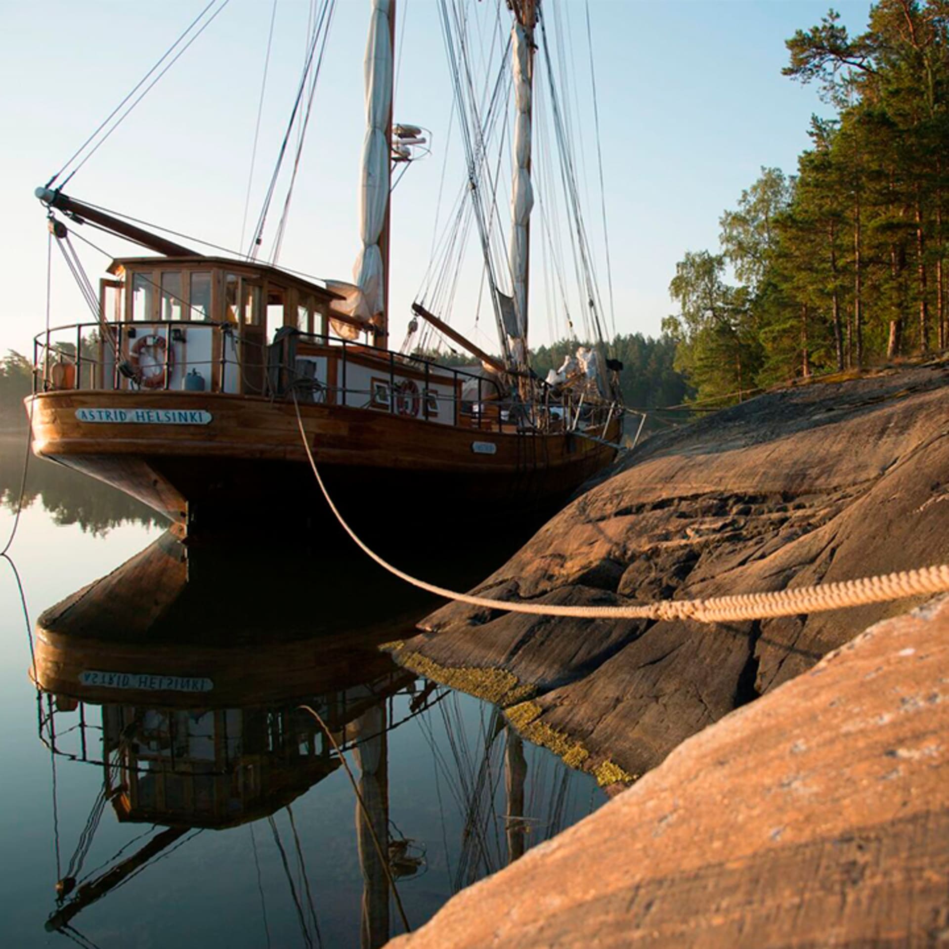 purjelaiva kiinnittyneenä saaren kylkeen