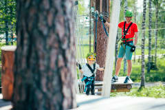 Pieni tyttö seikkailee lasten radalla Seikkailupuistossa.