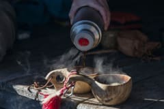 Retkeilijä kaataa kahvia kuksaan Pyhä-Luoston kansallispuistossa Ukko-Laavun taukopaikalla. Kuva: Teemu Kuisma /Metsähallitus