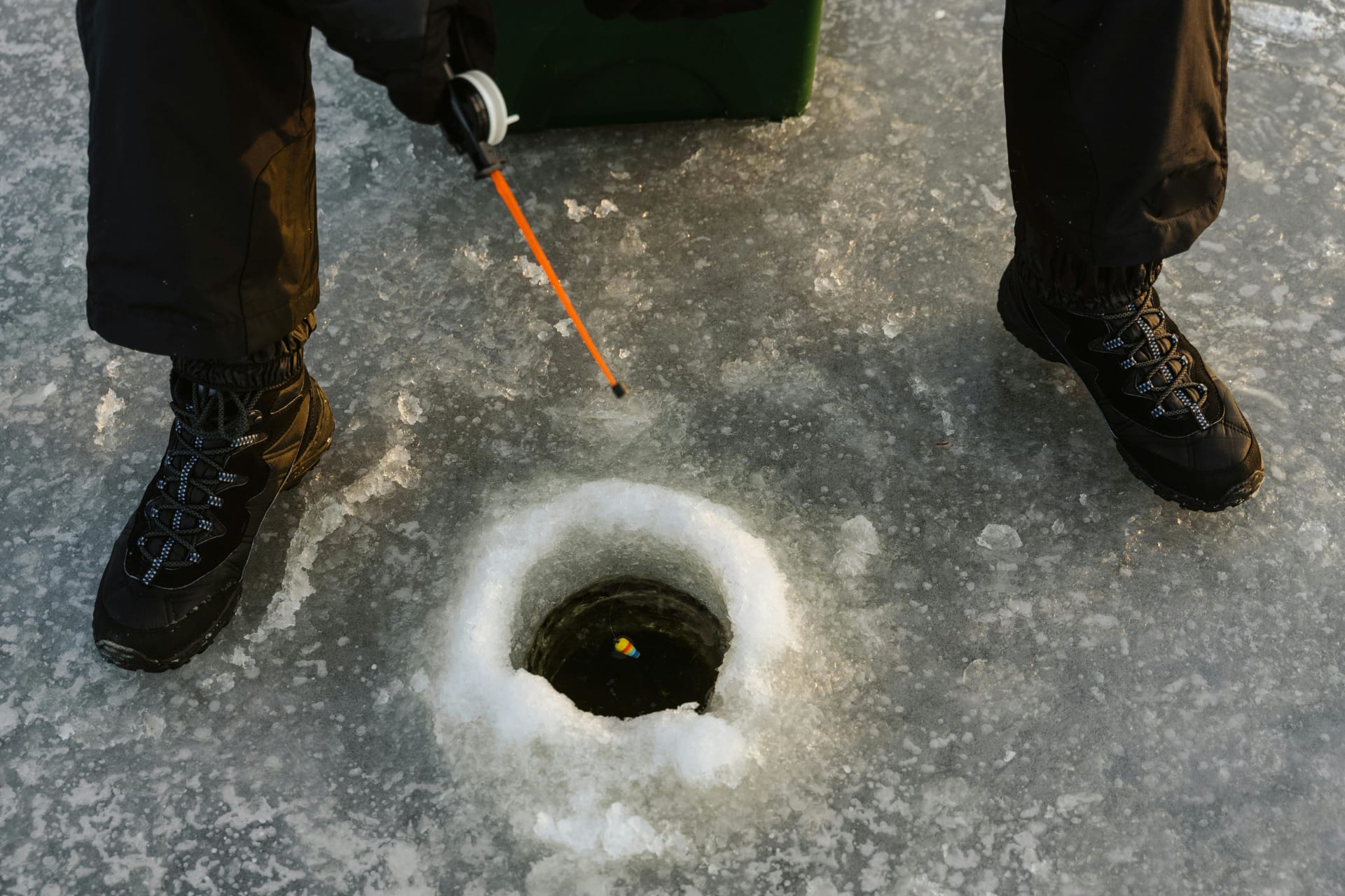 Ice fishing rod and a hole on the lake.