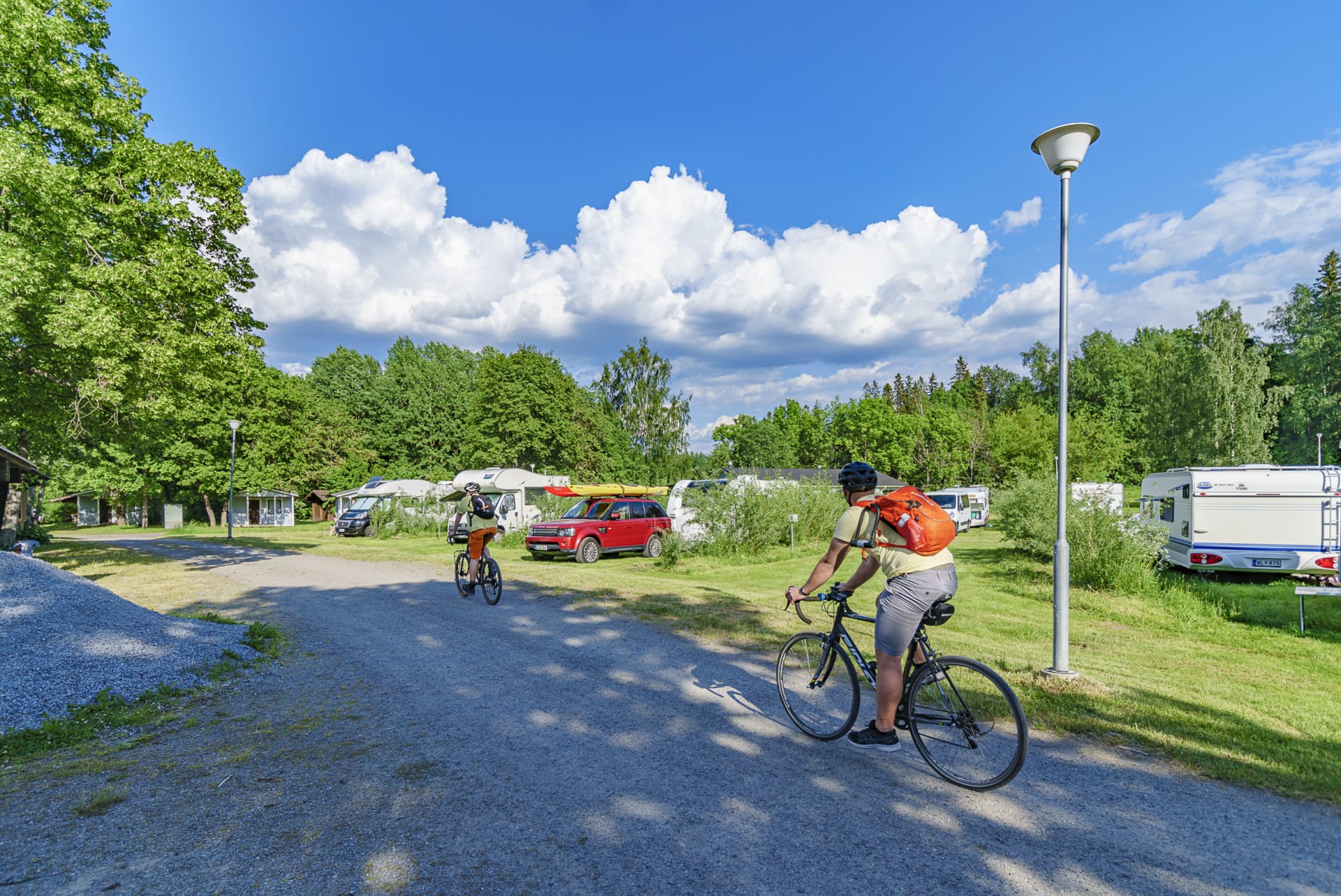 2 persons are cycling at the camping site.