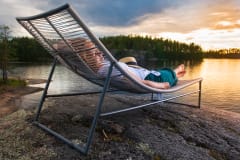 Nainen rentoutumassa kalliolla. A woman relaxing on the rock.