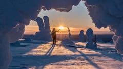 Retkeilijä talvisessa auringonlaskumaisemassa. Tykkylumisia puita ja koskematon hanki. / A hiker in a winter sunset landscape. Snow-covered trees and pristine snow. Kuva: Heikki Sulander