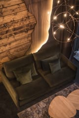A close-up view of a villa living room at Jänkä showing a sofa, wooden wall details, warm lighting, and a modern light fixture above.