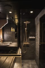 The interior of a private sauna in a Jänkä villa with wooden benches, a sauna stove, and soft, indirect lighting.