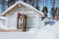 A person exiting the ice sculpted sauna in Apukka Resort