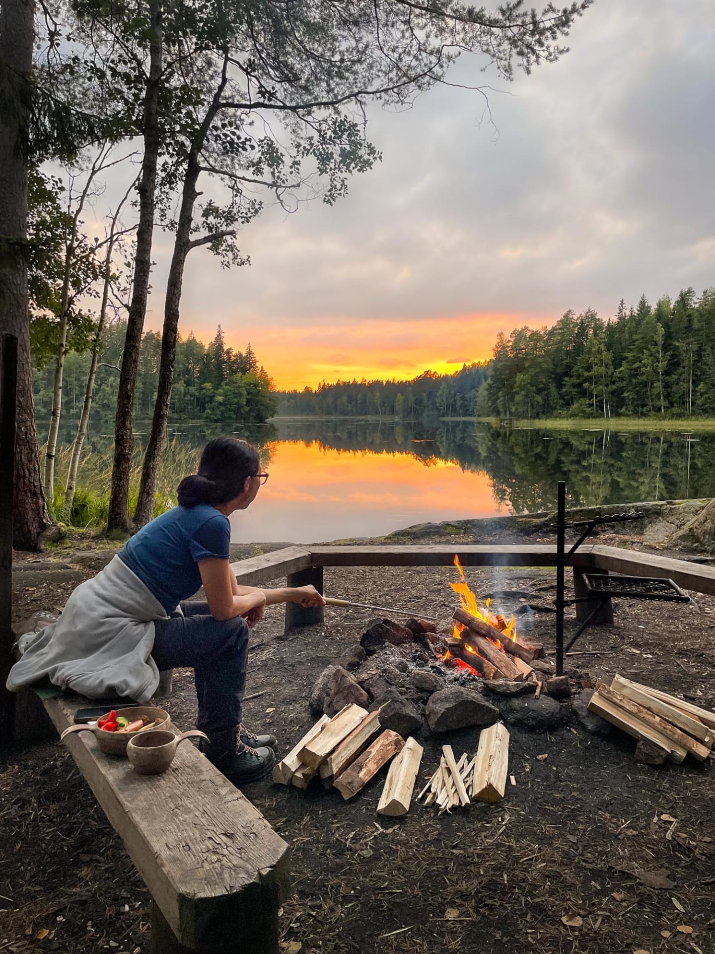 Hiker cooking lunch on campfire in Nuuksio