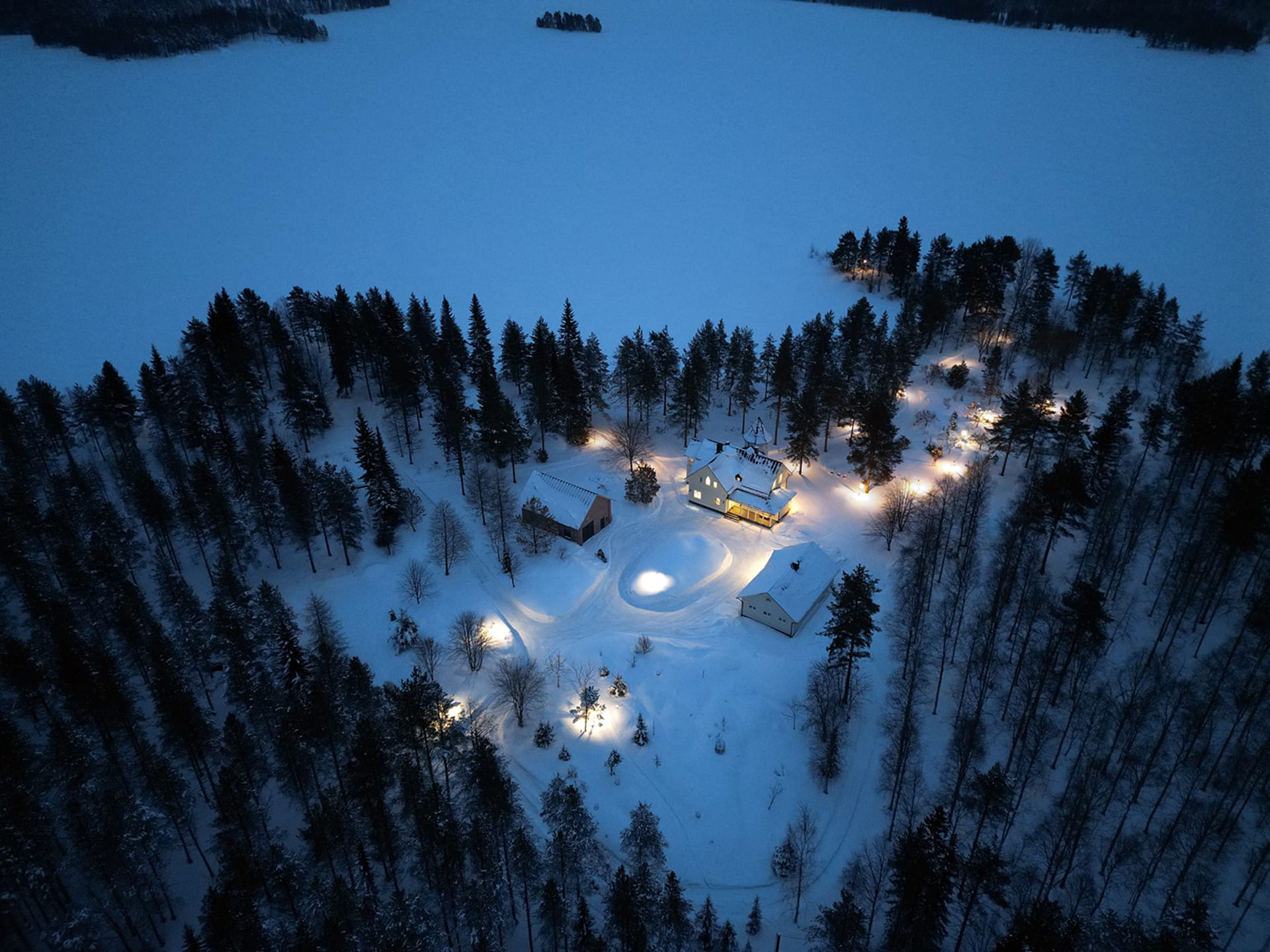 A bird’s-eye view of Villa Cone Beach and across the snowy Lake Korpijärvi into the wilderness, showcasing the place's privacy.