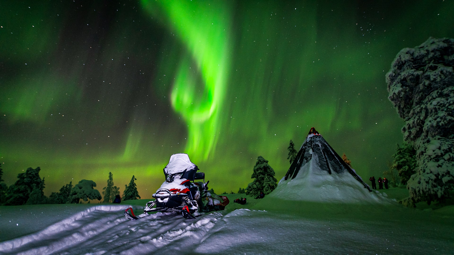 A bright green northern light strip and a snowmobile