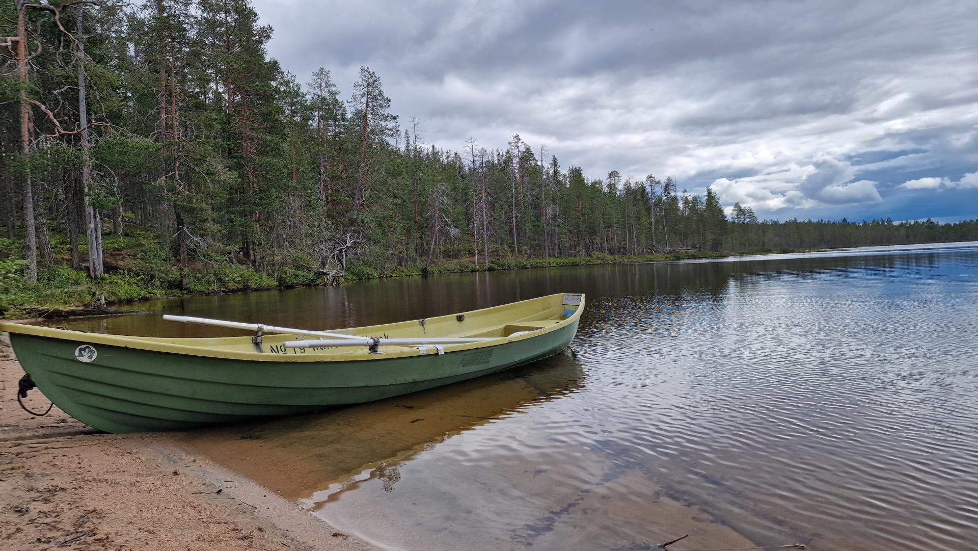Venevuokrausta Hossan kansallispuistossa, vene peilityynen järven rannalla Pitkä-Hoilualla