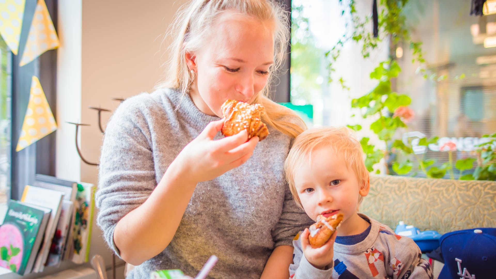 A woman and a child enjoying delicious Finnish cinnamon buns at Bakery Cafe Puusti, Tampere, Finland
