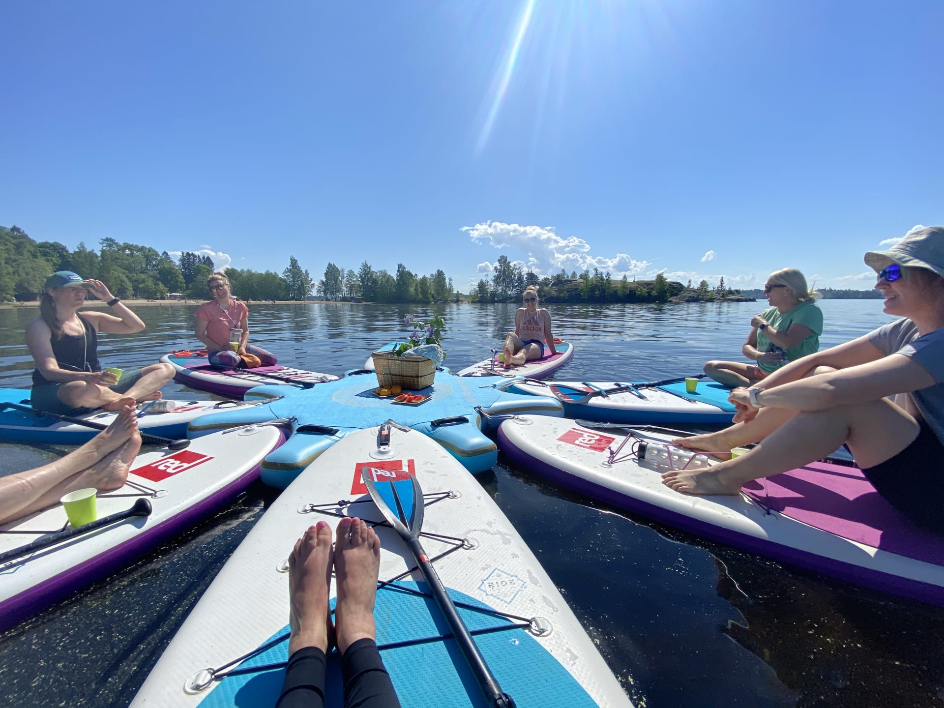 Group of people are sitting on sup boards on lake Pyhäjärvi.