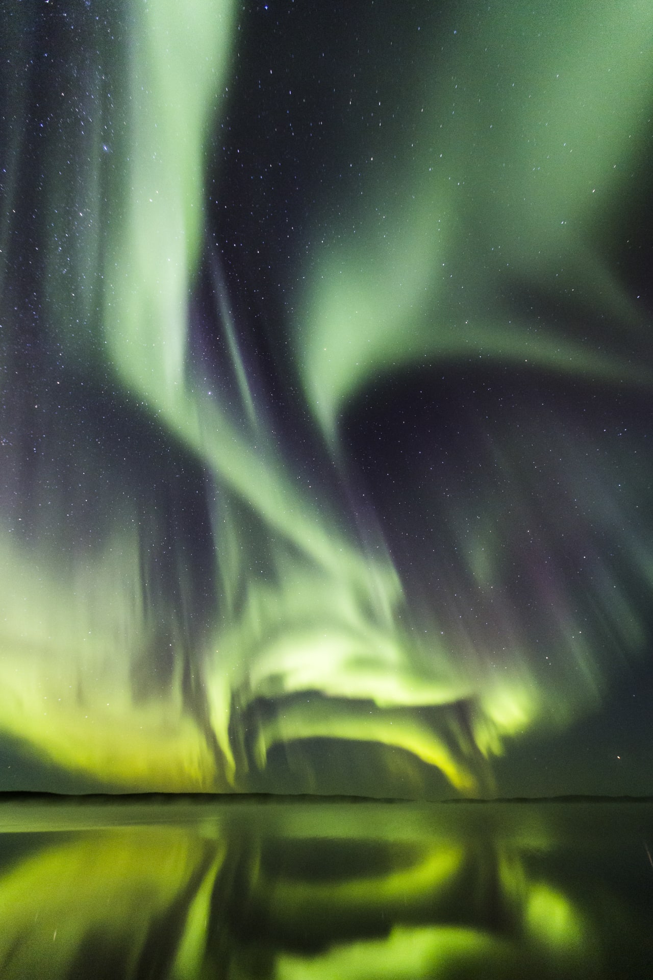 Aurora Borealis dancing in the night sky above Ranuajärvi Lake