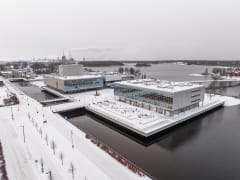 Laatikkomainen betonirakennus veden päällä.