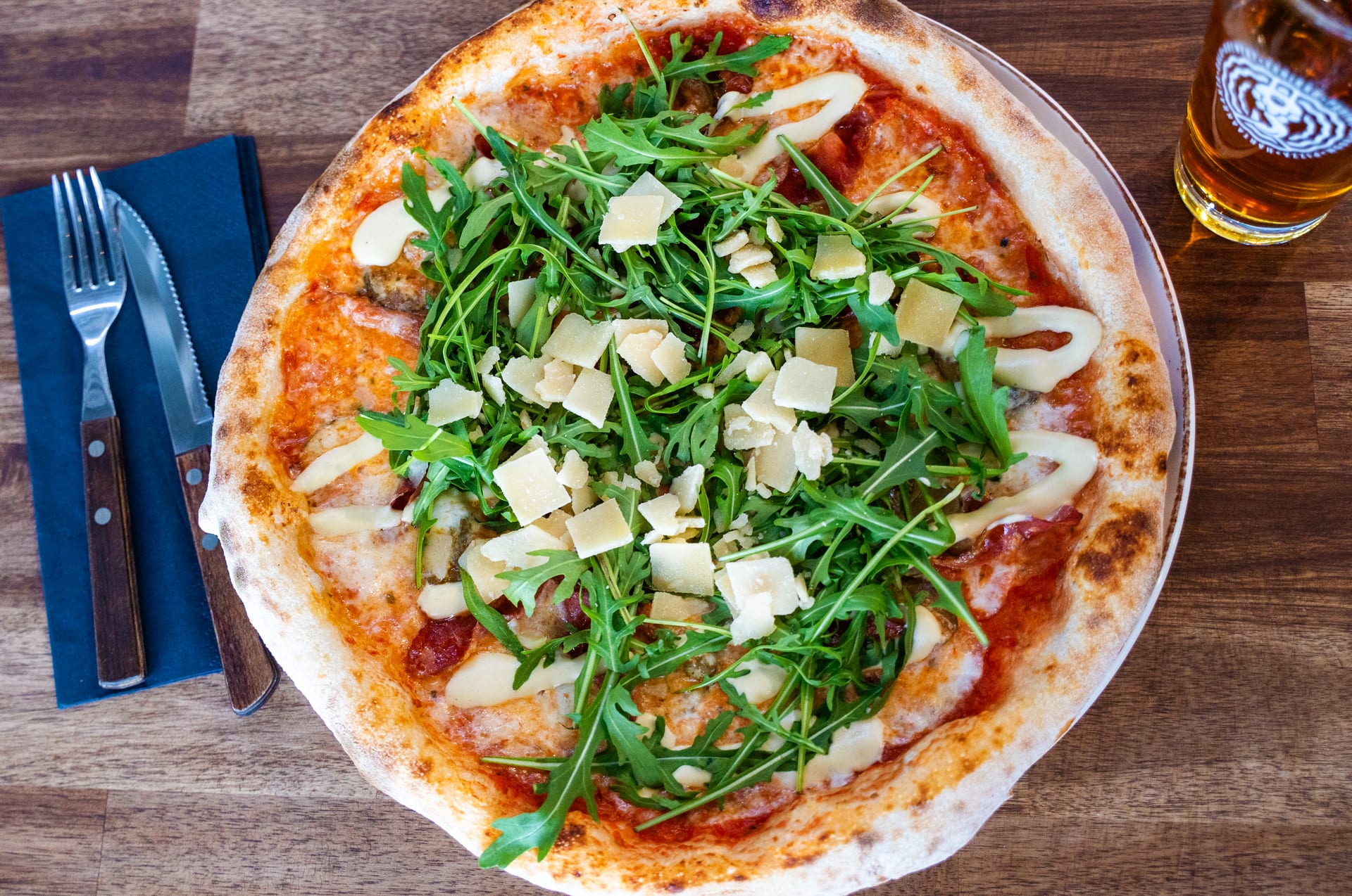 Delicious artisan pizza topped with fresh arugula and parmesan cheese