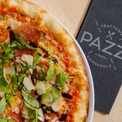 Pizza with ham, parmesan and rucola