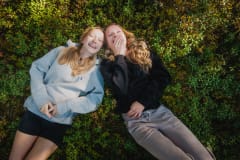 Two young adults laying on a field of berries and enjoying the peacedul moment