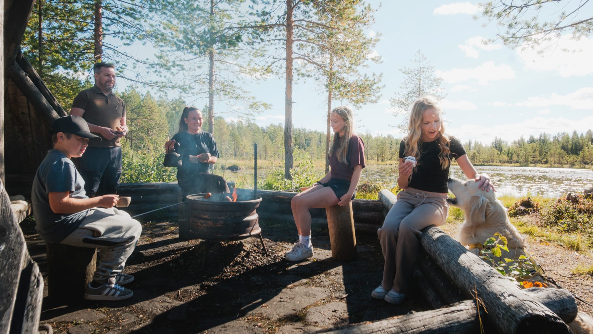 A family enjoying coffee and snacks by a lean-on shelter in nature