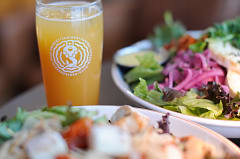 House-made long drink and fresh salads on a rustic table at Varikko brewery restaurant