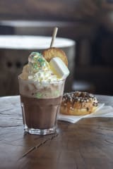 Donut and hot chocolate decorated with marshmallows, sprinkles and cookie.